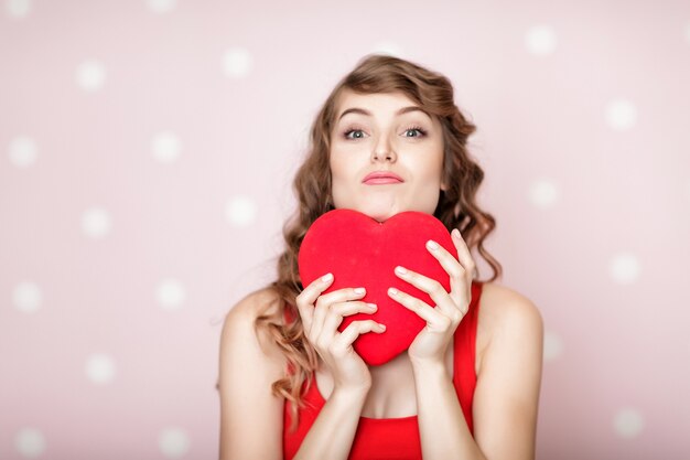 Belle femme souriante avec des coeurs rouges pour la Saint-Valentin