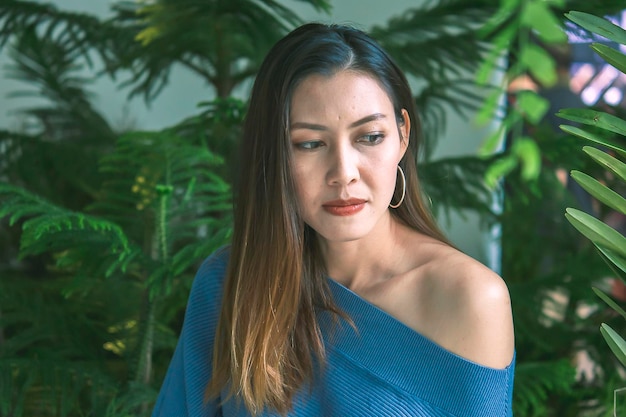 Photo une belle femme souriante contre les plantes.