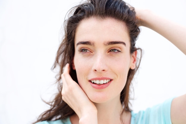 Belle femme souriante avec les mains dans les cheveux