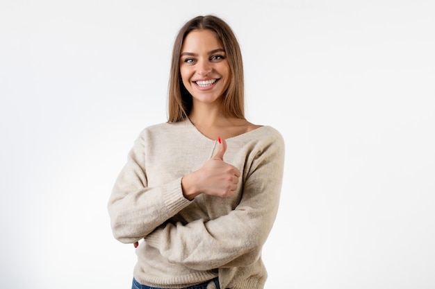 Belle femme souriante montrant les pouces vers le haut isolé sur blanc