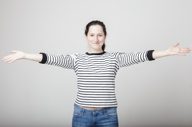 Belle femme souriante a placé les mains dans les parties dépeignant le geste de bienvenue