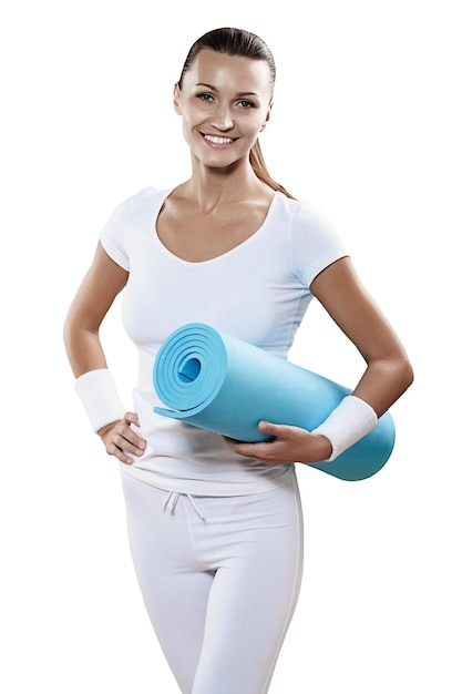 Belle femme souriante portait des vêtements de sport blancs tenant un tapis de yoga isolé