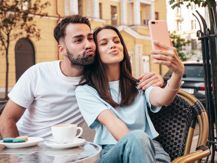 Photo une belle femme souriante et son beau petit ami boivent du thé et du café au café de la véranda en plein air.