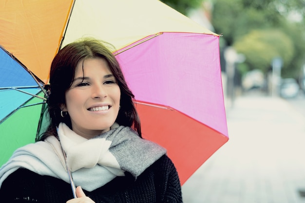 Belle femme sous un parapluie arc-en-ciel