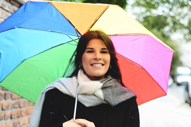 Belle femme sous un parapluie arc-en-ciel