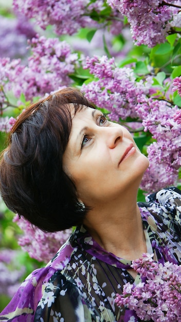 belle femme de taille moyenne dans le jardin de fleurs lilas