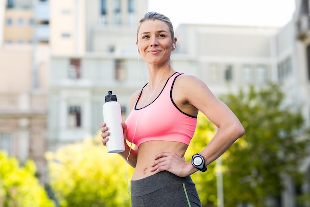 Une belle femme tenant une bouteille d&#39;eau de sport