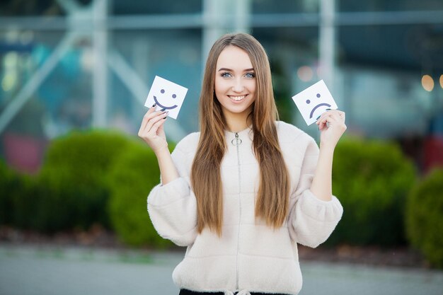 Belle femme tenant des cartes avec un sourire triste et drôle