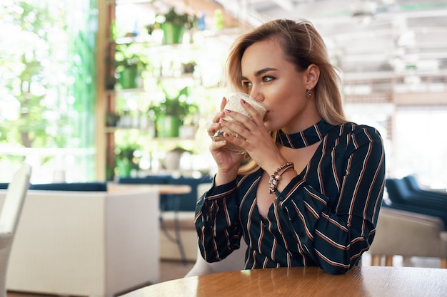 Belle femme tenant un cocktail dans ses mains