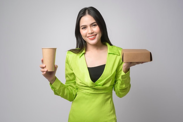 Belle femme tenant une tasse de papier et une boîte en papier sur fond blanc Sauver le concept de la terre