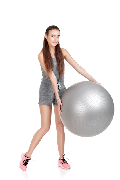 Belle femme en tenue de sport avec ballon de fitness isolé sur fond blanc