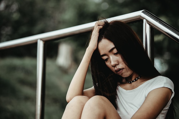 Belle femme thaïlandaise très triste d'un amour non partagé Elle repense et réfléchit à l'amourstyle vintageton sombrecoeur briséfille asiatique