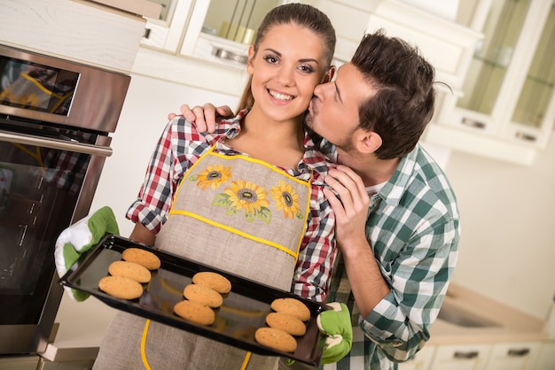 Belle femme tient une rôtissoire chaude avec des biscuits.