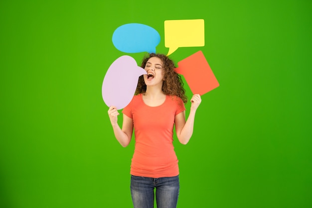 La belle femme tient des signes de dialogue sur le fond vert