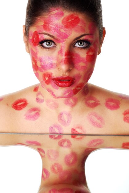 Belle femme avec des timbres de rouge à lèvres sur son visage