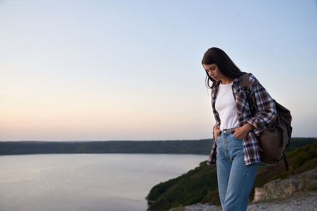 Belle femme touriste avec sac à dos marchant sur une haute colline près du fleuve Dniestr.