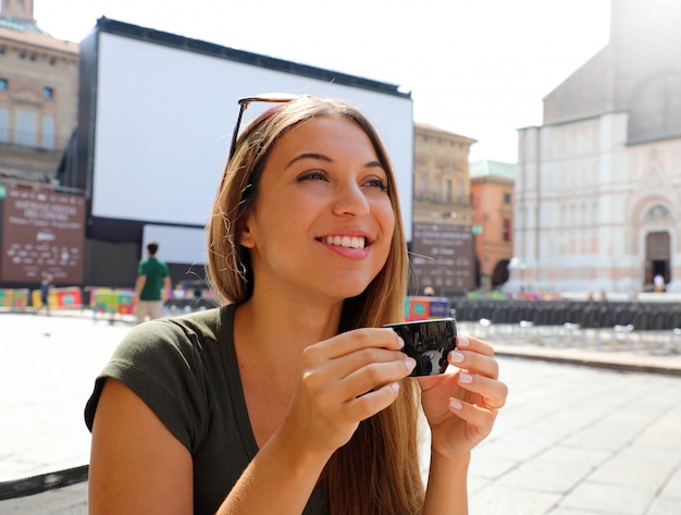 Belle femme touristique boit du café italien en plein air. Heureuse femme souriante avec une tasse de café sur un paysage italien ensoleillé.