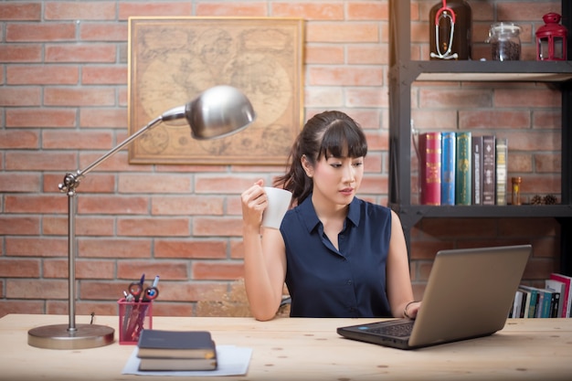 Belle femme travaille dans le bureau à domicile