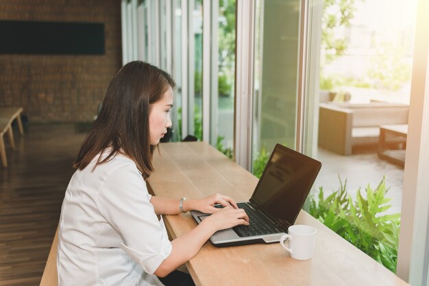 Belle femme utilisant un ordinateur portable au café