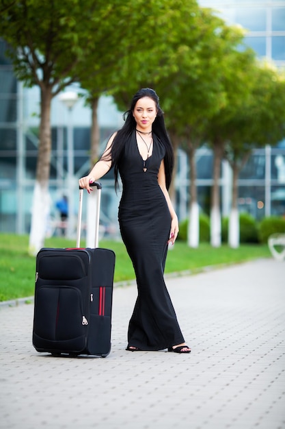 Belle femme avec une valise près de l'aéroport.