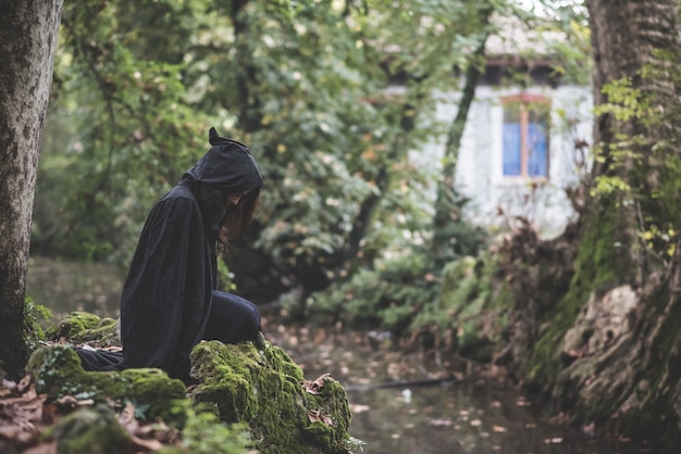 belle femme vampire sombre avec manteau noir et capuche