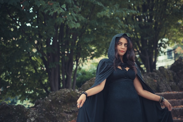 Photo belle femme vampire sombre avec manteau noir et capuche