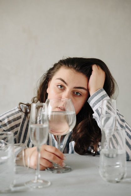 Photo belle femme avec des verres d'eau sur la table