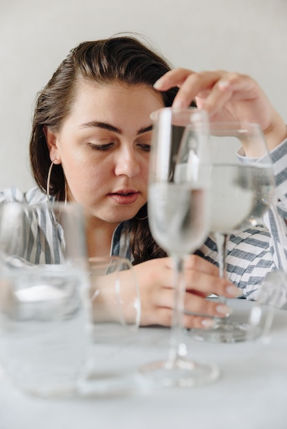 Belle femme avec des verres d'eau sur la table