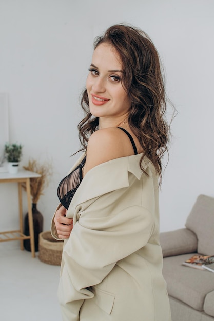 Belle femme en veste et soutien-gorge dans la chambre