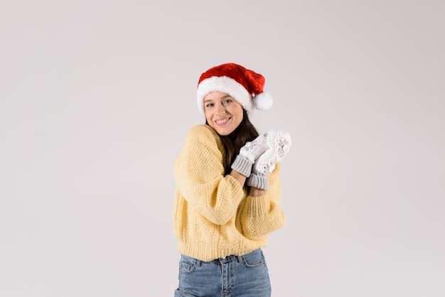 Photo belle femme en vêtements chauds chapeau de père noël rouge et mitaines blanches isolées sur fond blanc