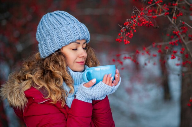 Belle femme en vêtements d'hiver, boire du thé