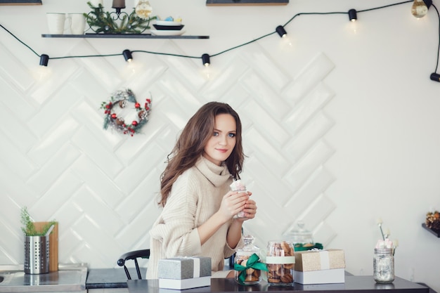 Belle femme en vêtements tricotés chauds à la maison