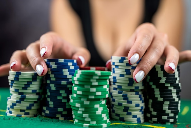 Belle femme vêtue d'une robe noire du soir joue au poker dans un casino à gros enjeux