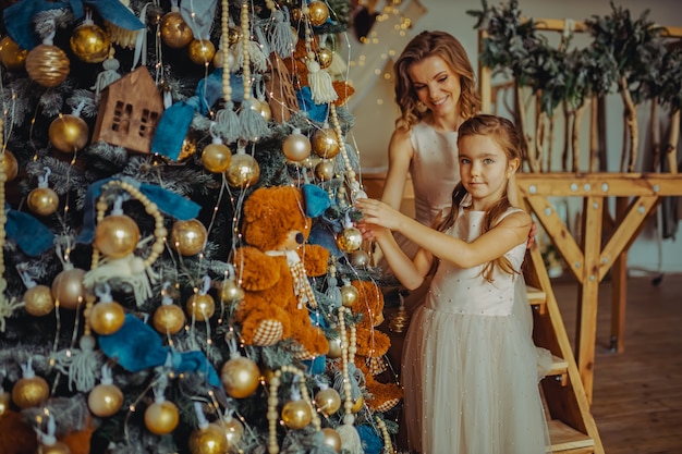 Belle femme vêtue d'une robe avec sa fille à Noël