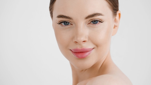 Belle femme visage lèvres roses. Maquillage naturel. Yeux de fille féminine de beauté saine. Isolé sur blanc.