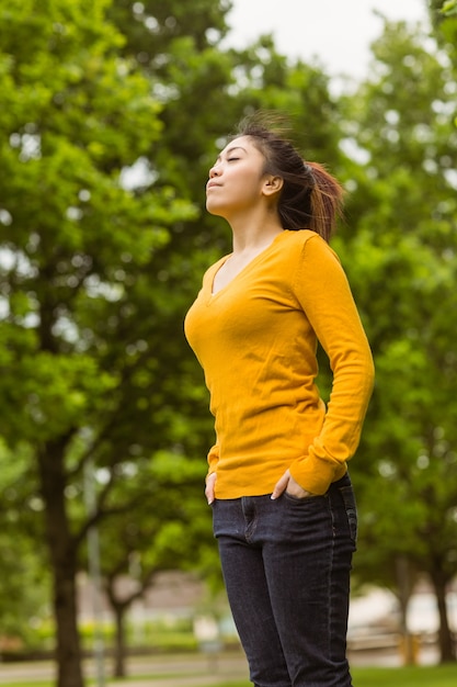 Belle femme avec les yeux fermés dans le parc