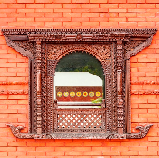 Belle fenêtre dans le mur de briques rouges d'un temple bouddhiste public en Chine