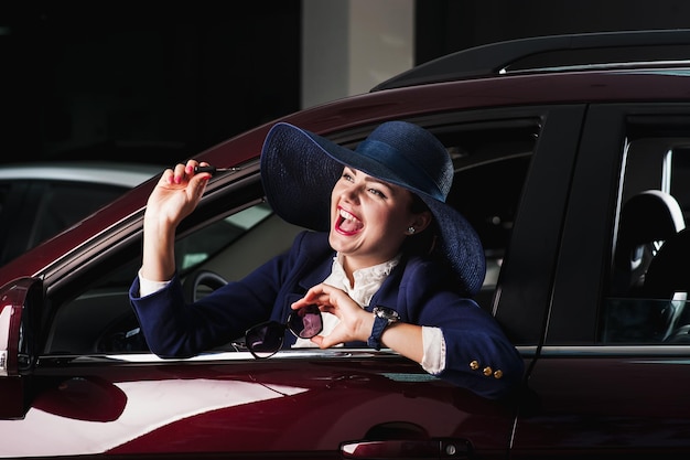 Belle fille achète une voitureDans les mains de la fille la clé de la voiture