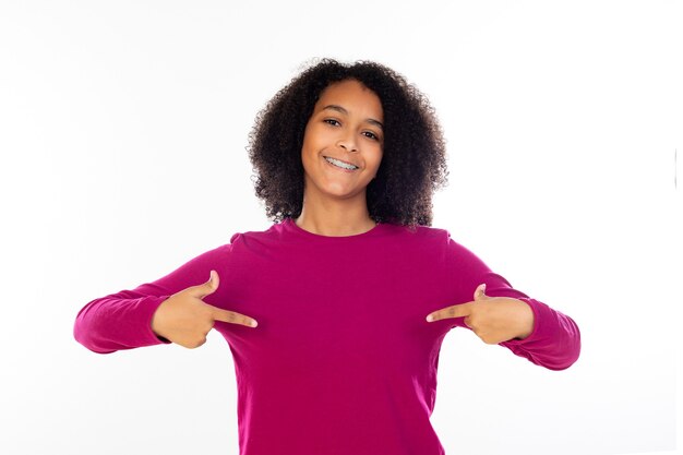 Belle fille adolescente avec pull rose isolé sur un mur blanc