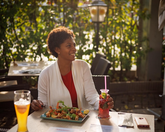 Belle fille afro-américaine dînant dans un café