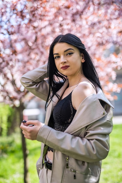 Belle fille appréciant la nature debout dans le jardin de printemps sous les branches d'arbres en fleurs