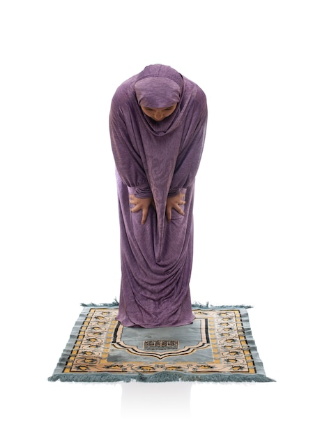 Belle fille arabe priant sur un tapis
