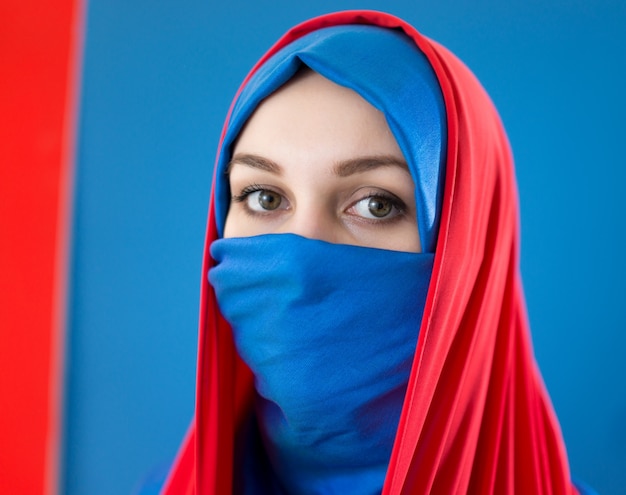 Belle fille arabe avec voile sur fond bleu