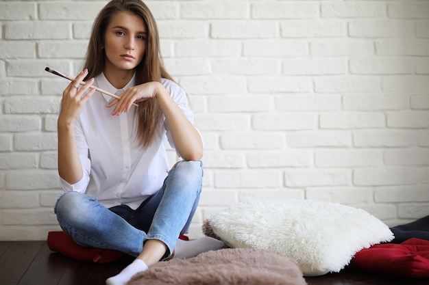 Belle fille artiste au travail dans un studio blanc créatif