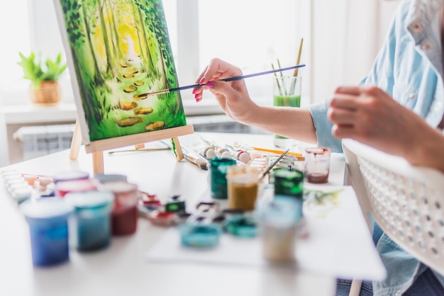 Belle fille artiste peint sur toile à la maison