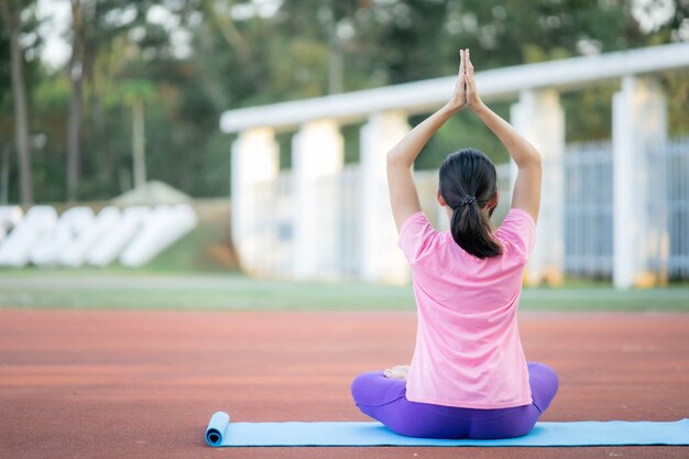 Belle fille asiatique faisant du yoga en plein air