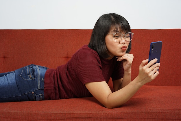 belle fille asiatique portant une chemise rouge et un jean bleu prendre un selfie