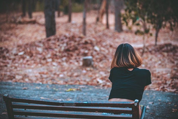 Une belle fille asiatique se sent seule dans la forêtConcept de femme tristeThaïlandeLady tristesse à propos de l'amour de son petit amiElle se sent le cœur brisé