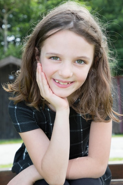 Belle fille assise sur l'herbe dans le parc