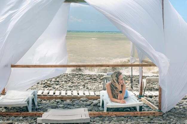 belle fille athlète se repose après la remise en forme au bord de la mer dans un belvédère de plage d'été